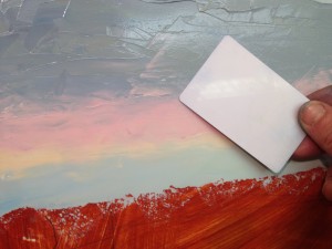 Using the corner of a credit card to blend the oil paints
